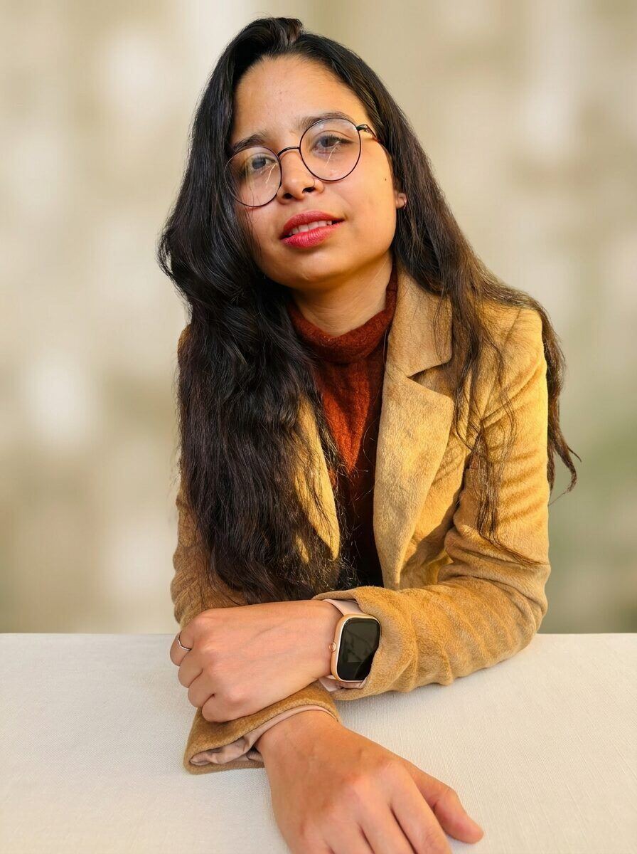 Portrait of Neha, content specialist for wellness brands, in a camel blazer, soft natural light